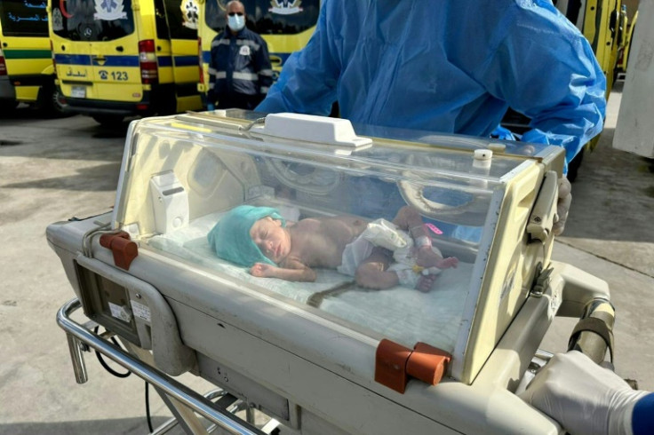 A premature Palestinian baby evacuated from Gaza is wheeled to an ambulance on the Egyptian side of the Rafah border crossing with the Gaza Strip