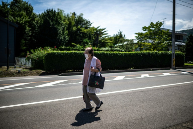 Tomoko Horino, 100, walks to the bus on her way to visit clients