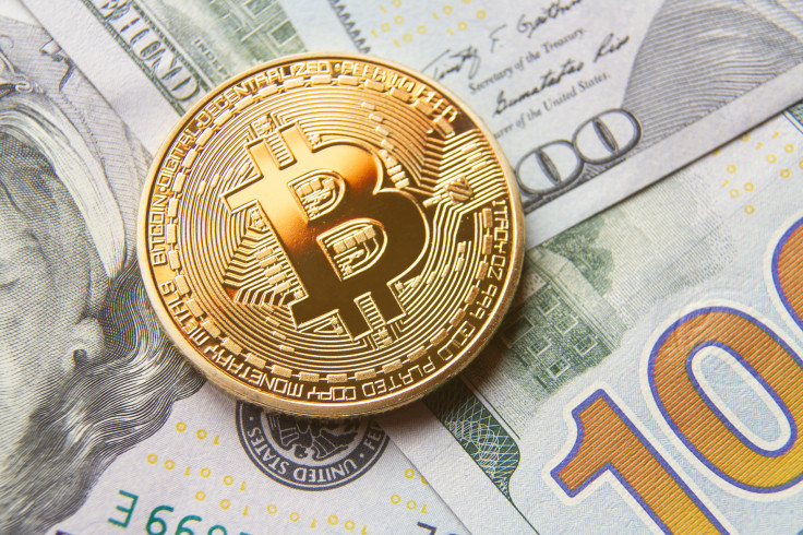 Single bitcoin with gold reflection on top of background of 