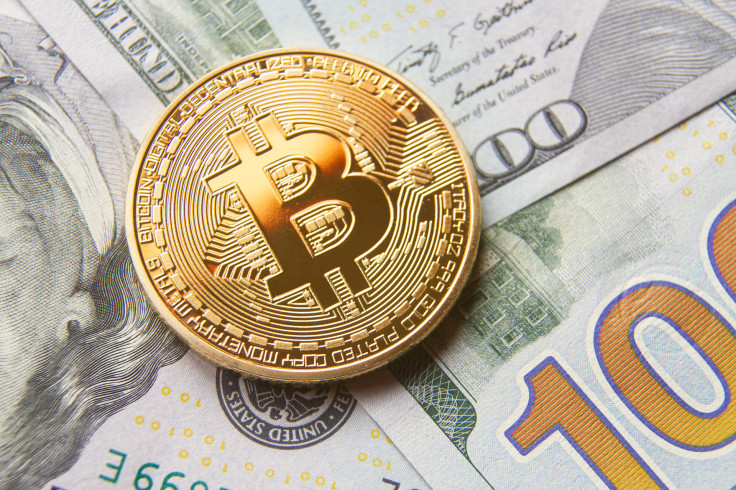 Single bitcoin with gold reflection on top of background of
