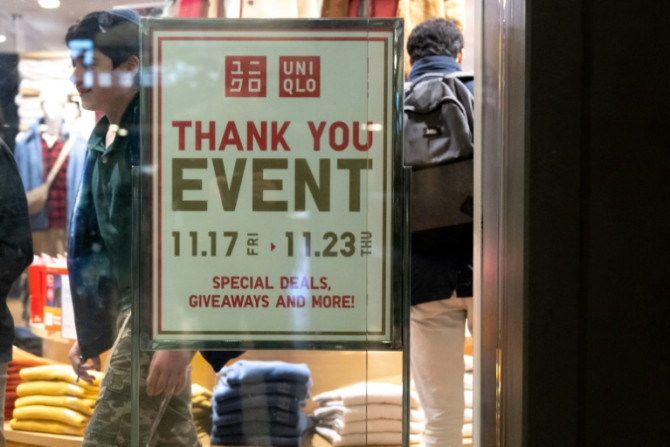 A person walks past a sales advertisement at Uniqlo Department Store at Union Station in Washington on November 21, 2023