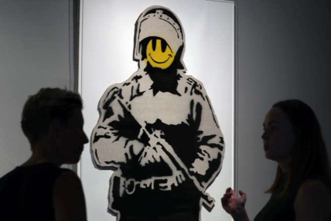 "Smiling Copper" a work on show in Barcelona by mysterious British artist Banksy, who has revealed in a 20-year-old interview that his first name is "Robbie".