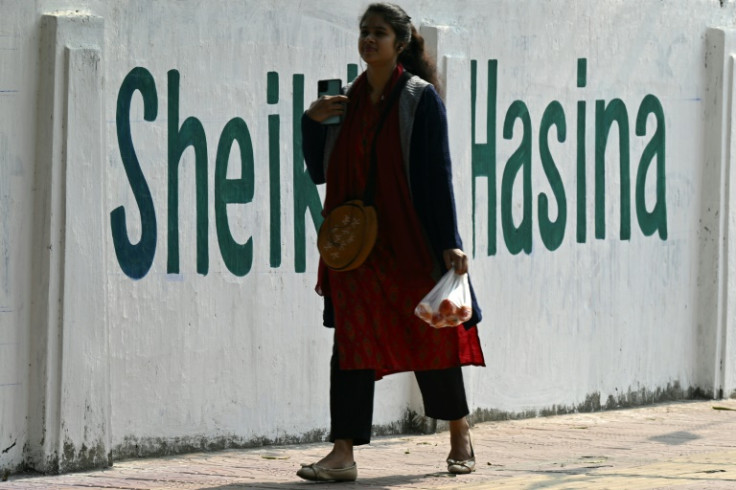 A woman walks past a wall praising Prime Minister Sheikh Hasina in Dhaka on January 6. Supporters point to her economic achievements, critics to her record on human rights