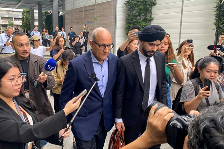Singaporean transport minister S. Iswaran (centre L) leaves court after an appearance on Thursday