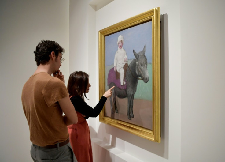 Visitors look at an oil painting entitled "Paul on a donkey" during the official unveiling of  a new exhibition of works by Pablo Picasso at Malaga's Picasso Museum.