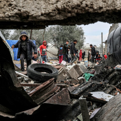 Displaced Palestinians inspect the damage to their tents following overnight Israeli bombardment in Rafah