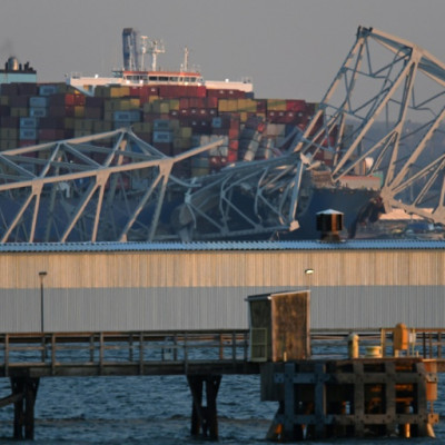 The steel frame of the Francis Scott Key Bridge sits on top of a container ship after the bridge collapsed in Baltimore, Maryland, on March 26, 2024