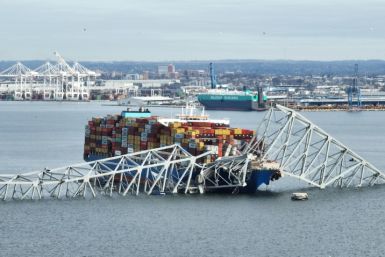 In this aerial image, the steel frame of the Francis Scott Key Bridge sits on top of a container ship after the bridge collapsed in Baltimore, Maryland on March 26, 2024