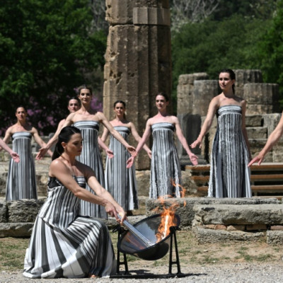 Greek actress Mary Mina, playing the role of the High Priestess, lights the torch during the rehearsal of the flame lighting ceremony