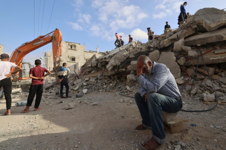 A Gazan waits for news of his daughter as rescue workers search for survivors under the rubble of a destroyed building in Rafah