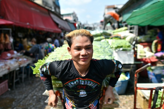 A vendor sweats as he pulls a vegetable cart at Khlong Toei Market in Bangkok on Thursday