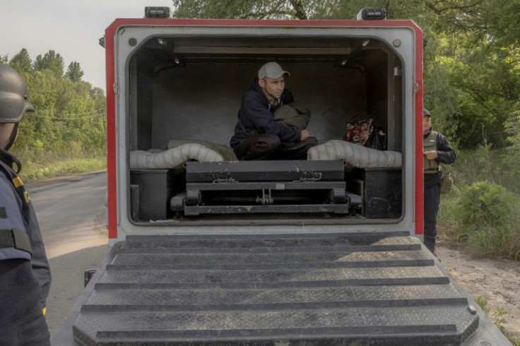 Oleksandr, an evacuee from the frontline village of Lyptsi arrives in an armoured vehicle at a checkpoint
