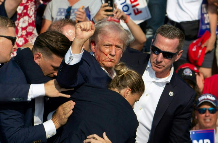 A woman Secret Service agent can be seen helping to bundle a bloodied Donald Trump from the stage after an assassination attempt in Pennsylvania on July 13