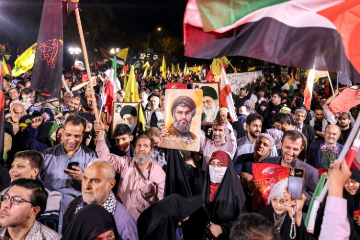 A crowd celebrated the Iranian strikes on Tuesday in Tehran, some of them holding posters of slaim Hezbollah leader Hassan Nasrallah