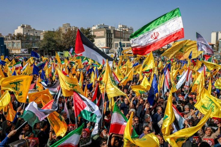 Mourners in Mashhad, Iran, wave flags of Iran, Palestine, and Hezbollah during a funeral procession for General Abbas Nilforoushan, killed in an Israeli air strike in Beirut