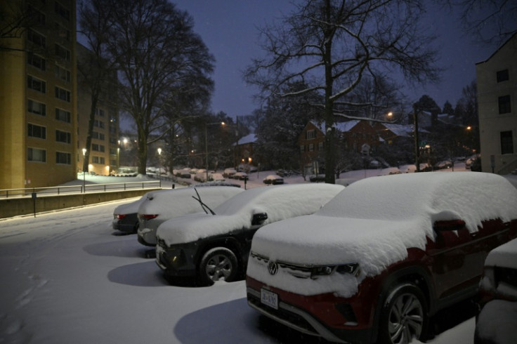 Cars are covered in snow during a winter storm in a residential area of Washington, DC, early on January 6, 2025