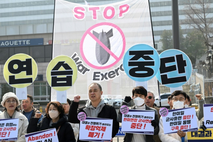 South Korean protesters hold banners that collectively read "Stop the military exercise between the US and South Korea" during a rally in front of the Defence Ministry in Seoul on March 10