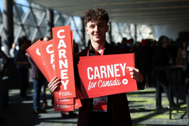 A supporter holds up signs for former Bank of Canada and Bank of England governor Mark Carney at the Liberal Party of Canada Leadership convention on March 9, 2025 in Ottawa