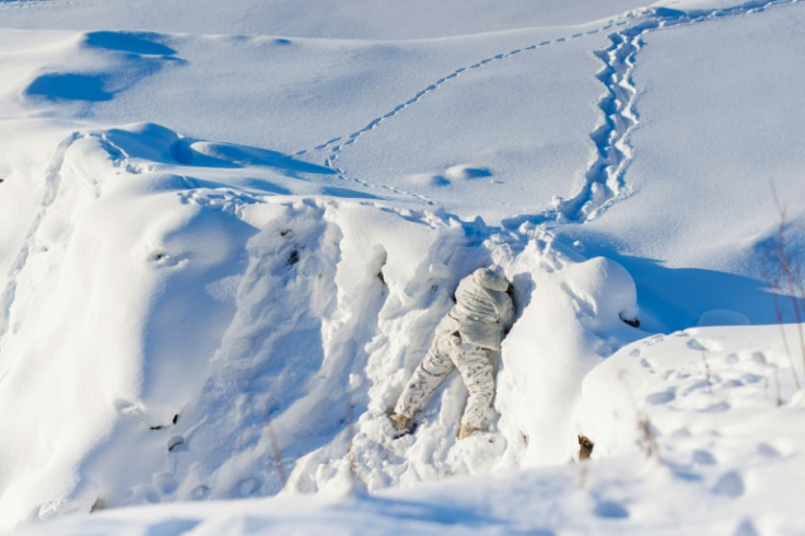 A Canadian sailor peers over a ridge as a team from the Canadian Navy test thermal imaging drone capabilities in Arctic environments, during Operation Nanook, the Canadian Armed Forces' annual Arctic training and sovereignty operation, in Inuvik, Northwes