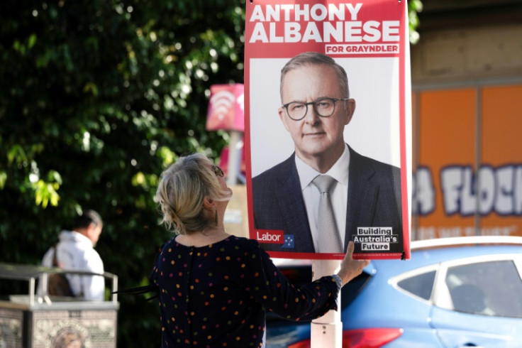 A volunteer replaces campaign posters of Australia's Prime Minister Anthony Albanese with new ones in his Sydney electorate ahead of a general election May 3.