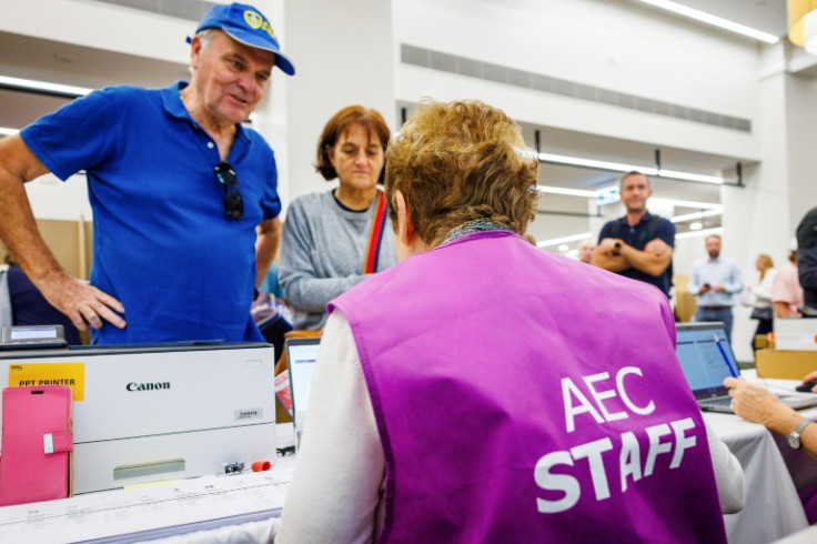 Voters get their ballots from election volunteers at a pre-polling centre in Brisbane on the eve of Australia's May 3 general election.
