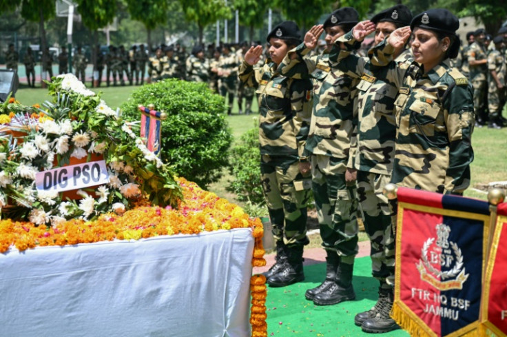 Indian Border Security Force soldiers salute during the funeral Tuesday of a colleague killed during the clashes with Pakistan